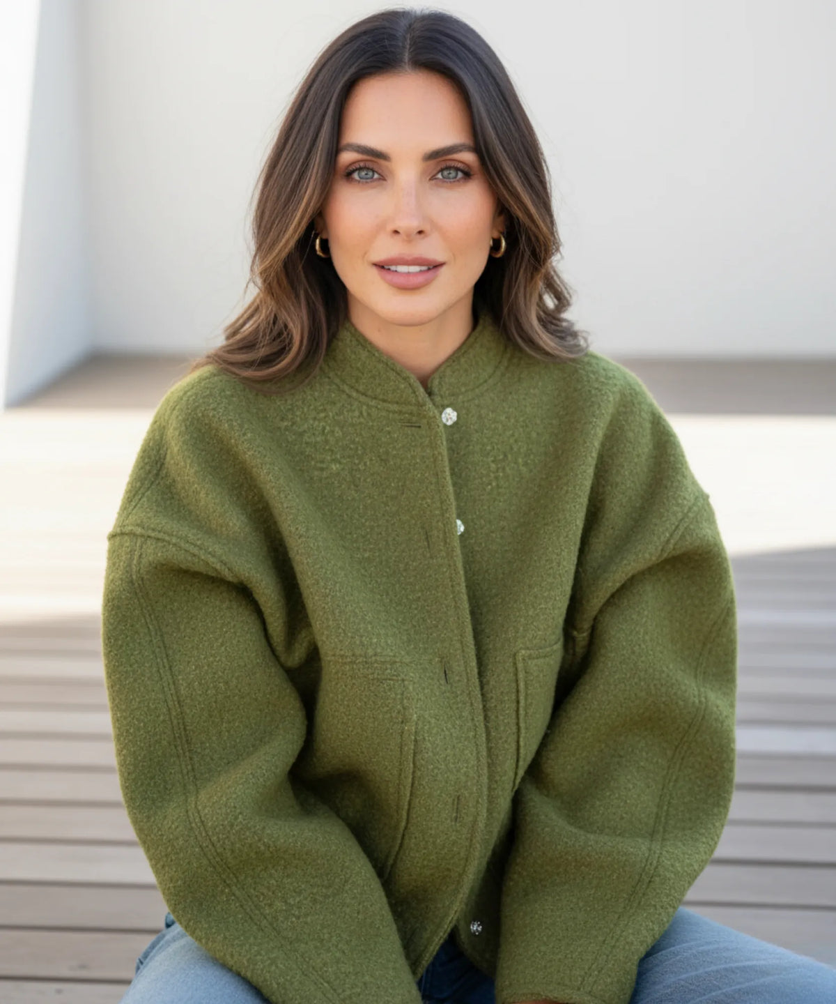Vrouw in charcoal bouclé bomberjack — informeel elegante look