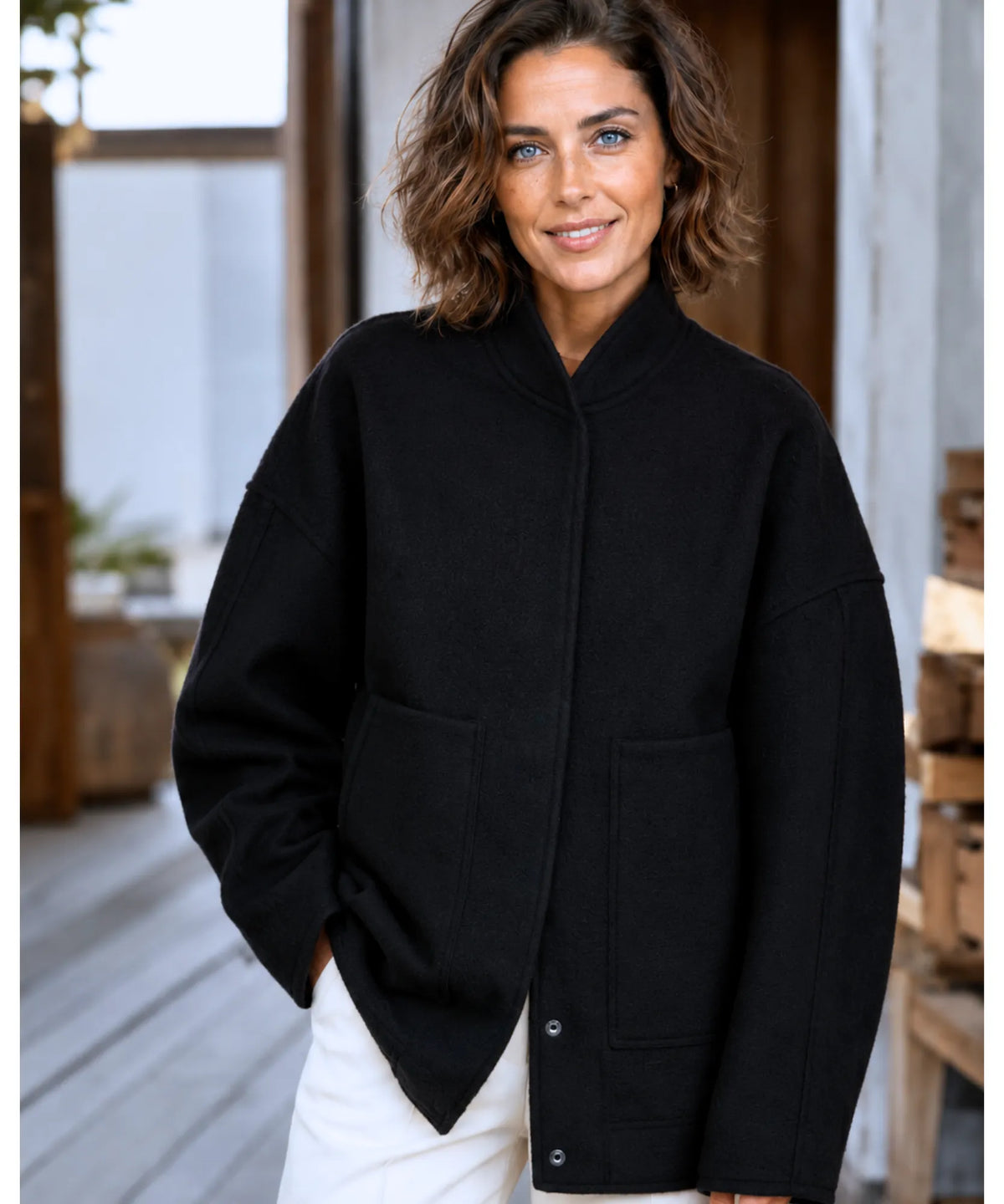 Vrouw in grijs oversized bouclé bomberjack — zijdelings silhouet