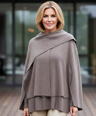 Vrouw in oversized wollen wrapjas in taupe kleur