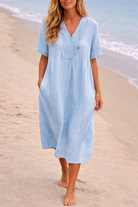 Vrouw in casual linnen midi jurk groen op het strand