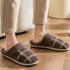 Relax pantoffels bruin op houten vloer thuissituatie